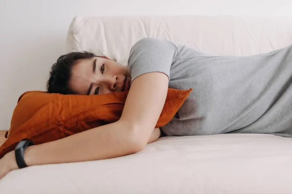 Жінка в сірому одязі спить і розслабляється на дивані в квартирі . — стокове фото