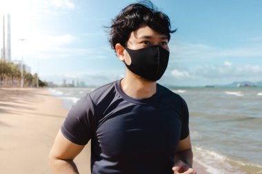 Adam yaz sabahı plajda maskeyle koşuyor..