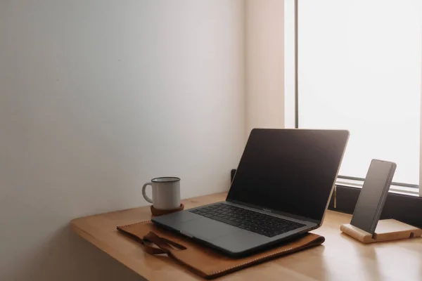 Laptop-Arbeitsplatz auf Holzschreibtisch an den Fenstern. — Stockfoto