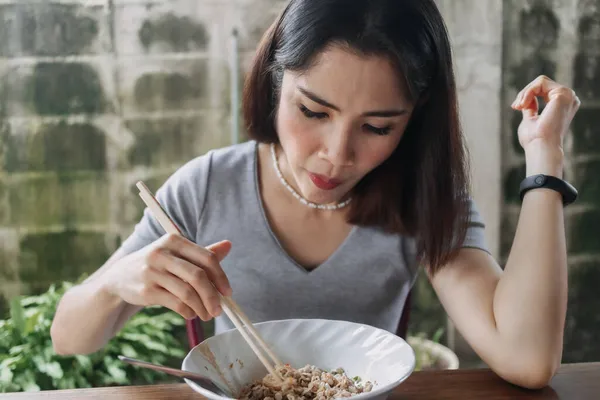 Wanita makan mie pedas dengan sumpit di jalan lokal. — Stok Foto