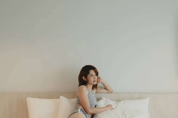 美しい幸せな女性が座って、週末の朝にベッドでリラックス. — ストック写真