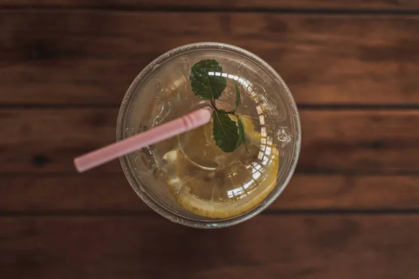 Soda citron en verre plastique sur table en bois dans le café. — Photo
