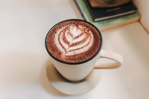 Kopi latte panas disajikan dalam cangkir putih di atas meja di pagi hari. — Stok Foto