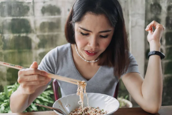 Woman eat spicy noodles with chopsticks in local street. — Stock Photo, Image