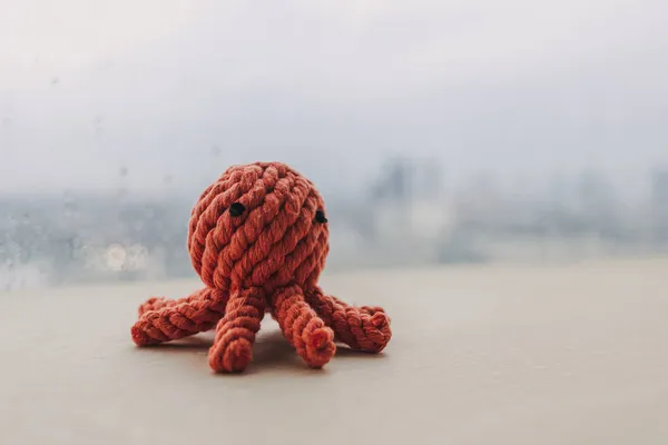 Poupée jouet tricot pieuvre rouge à la main sur bureau en bois avec espace de copie. — Photo