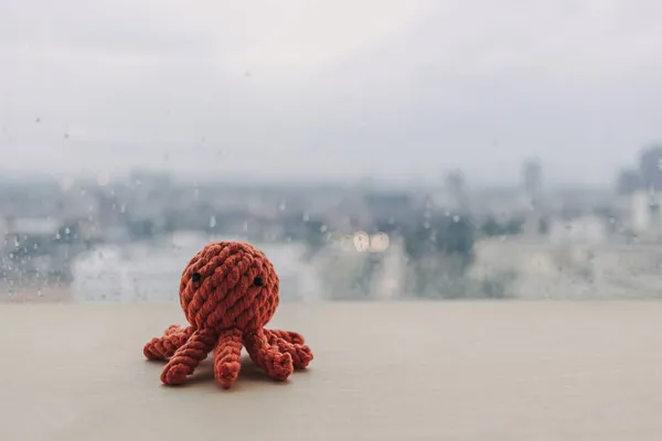 Rote Krake strickt handgemachte Spielzeugpuppe auf Holztisch mit Kopierraum. — Stockfoto