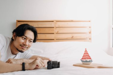 Adam yatak odasında oyuncak tekne modelini hobi olarak kullanıyor..