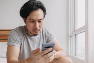 Akıllı telefonlara ciddi ciddi bakan bir adam..