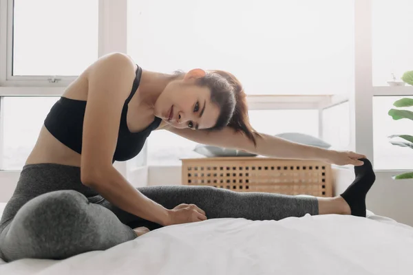 Mulher se alongando e esfriar após o treino em seu quarto de apartamento. — Fotografia de Stock