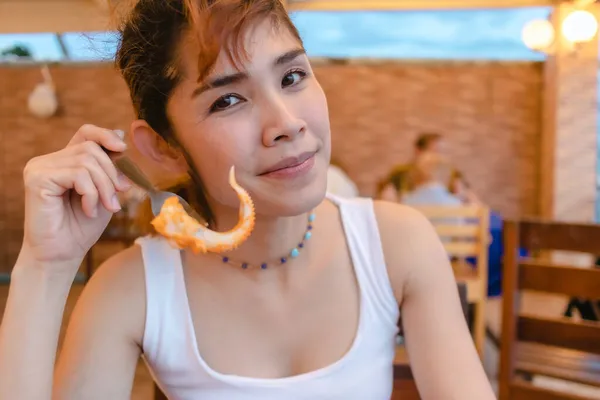 Mujer feliz disfrutar de comer mariscos calamar en las vacaciones de verano. —  Fotos de Stock