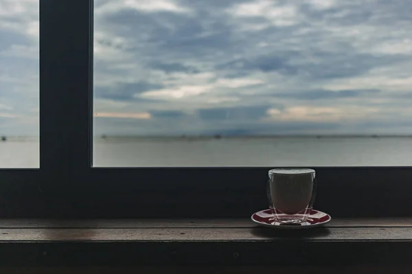Barda bir fincan kahve, akşam deniz manzaralı.. — Stok fotoğraf