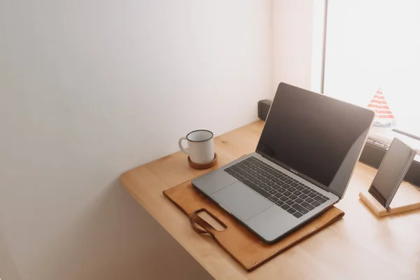 Laptop-Arbeitsplatz auf Holzschreibtisch an den Fenstern. — Stockfoto