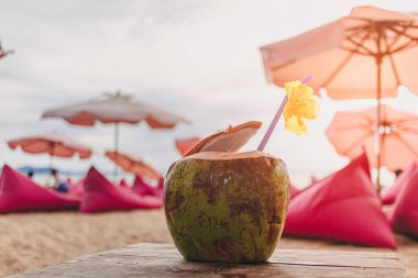 Yazın kumsaldaki kafede çiçeklerle süslenmiş hindistan cevizi..