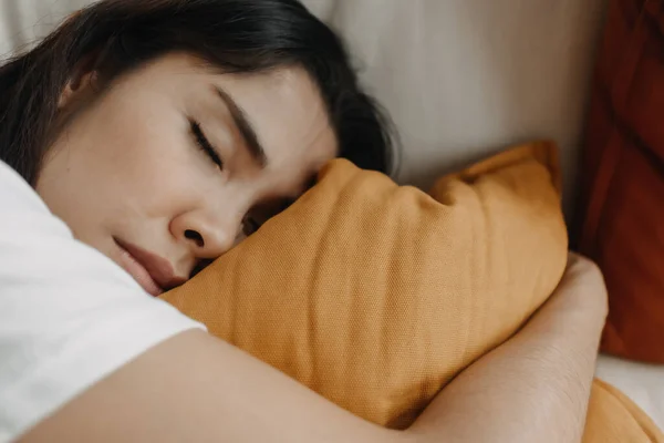 여자가 낮잠을 자거나 소파에서 노란색 베개를 들고 잠을 자고 있다. — 스톡 사진
