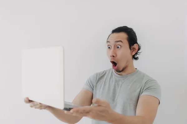 Shocked and surprised face of man looking at the laptop in his hand. — Stock Photo, Image