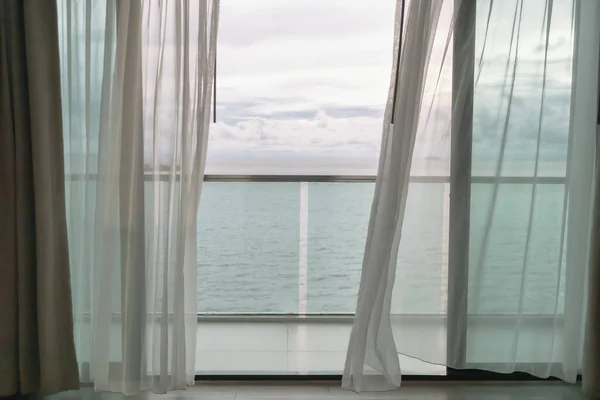 Otelin balkonundan perdeli okyanus manzaralı akşam vakti..