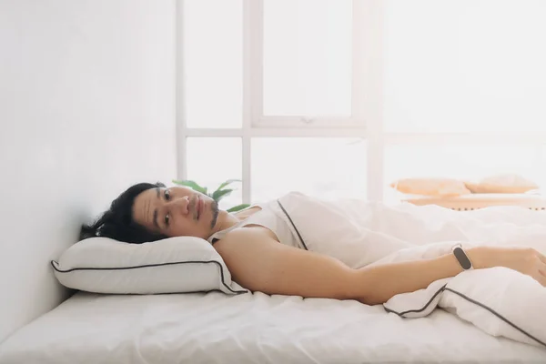 L'homme vient de se réveiller dans un matin heureux dans une chambre blanche lumineuse. — Photo