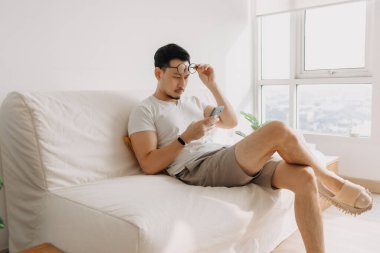 Uzun görüşlü orta yaşlı bir adam. Akıllı telefona bakmaya çalış..