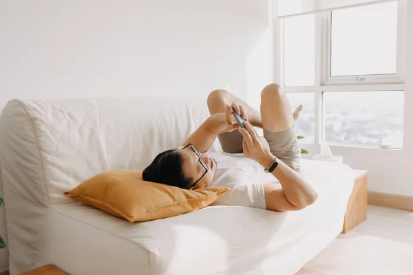 Homme adulte s'amuse à jouer jeu mobile dans le salon appartement. — Photo