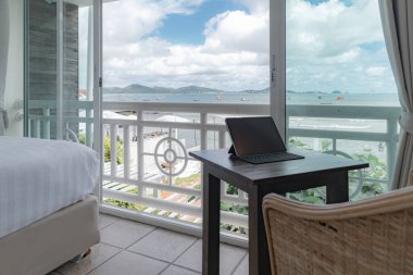 Tablet, deniz manzaralı otel odasının balkonunda..