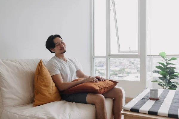 幸せな男が座って、アパートのリビングルームのソファにリラックス. — ストック写真