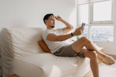 Uzun görüşlü orta yaşlı bir adam. Akıllı telefona bakmaya çalış..