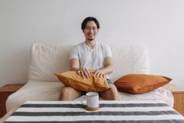 Oturma odasında kahveli rahat bir adam..