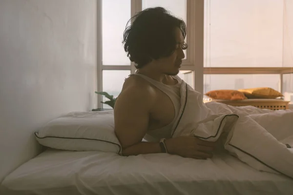 El hombre acaba de despertar en una mañana feliz en el dormitorio blanco brillante. — Foto de Stock