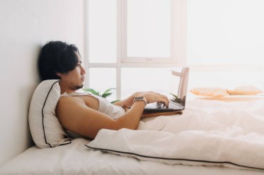 Adam uyanır ve sabah ilk iş olarak laptopla yatakta çalışır..