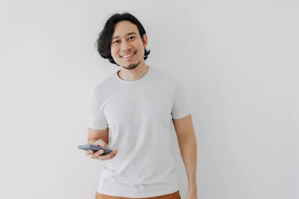 Счастливый человек использует смартфон на белом фоне и в пространстве для копирования. — стоковое фото