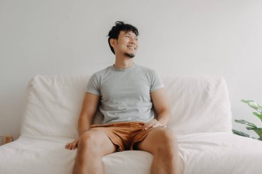 Mutlu adam dairesindeki kanepede oturuyor. Rastgele kavramı ve rahatlama.