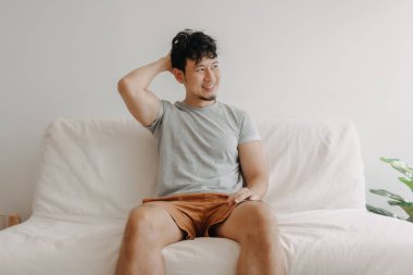 Mutlu adam dairesindeki kanepede oturuyor. Rastgele kavramı ve rahatlama.