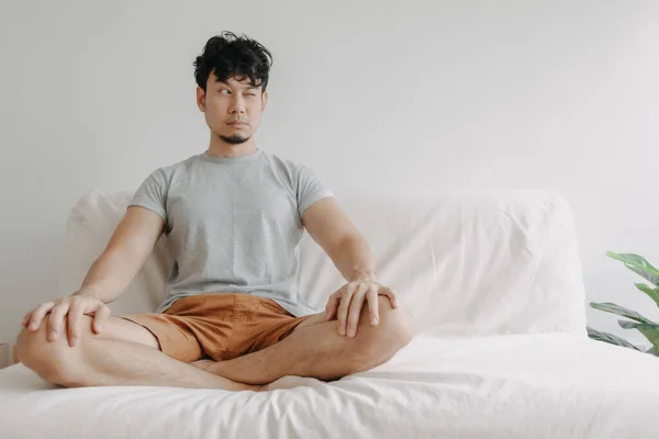 Man does meditation on the sofa with little distraction. — Stock Photo, Image