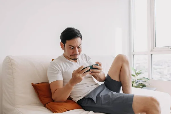 Funny man seriously focus on his mobile game in his relax day. — 스톡 사진