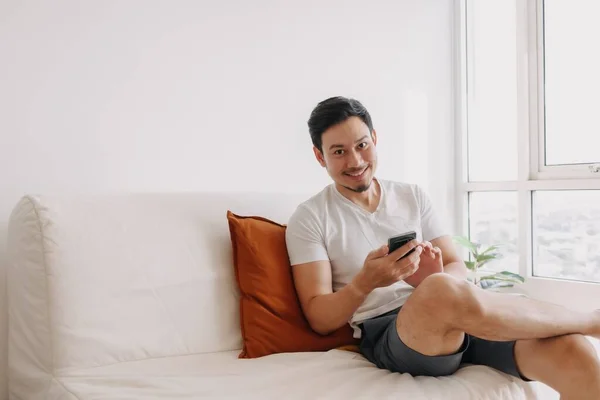 Happy man using smartphone in his living room in a casual day. — Stok Foto