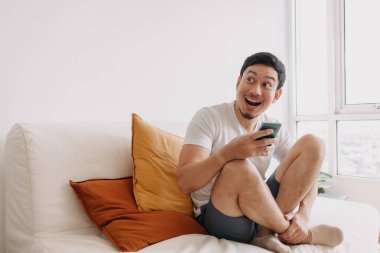Shocked and Surprised man using smartphone looking at the empty space.