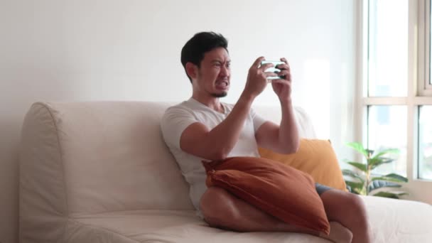 Mann konzentriert und konzentriert auf das Spiel mit dem Smartphone. — Stockvideo