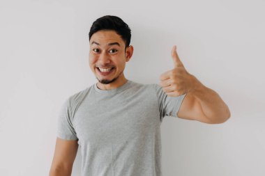 Mutlu Asyalı adam beyaz arka planda iyi bir el işareti olarak baş parmağını gösteriyor..