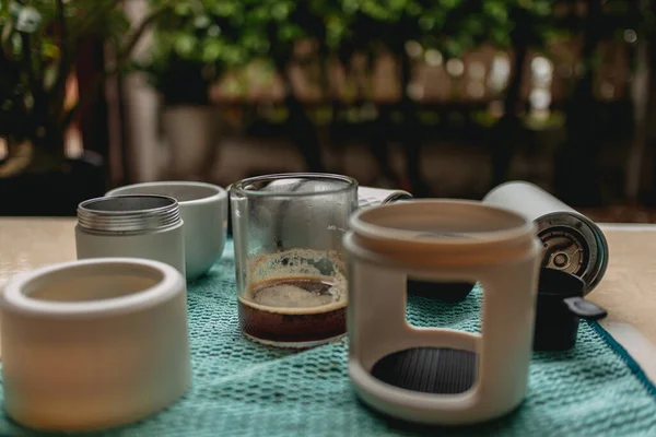 Portatif Fransız presi seti ve yeşil kumaş üzerinde öğütücü kahve ekipmanları..