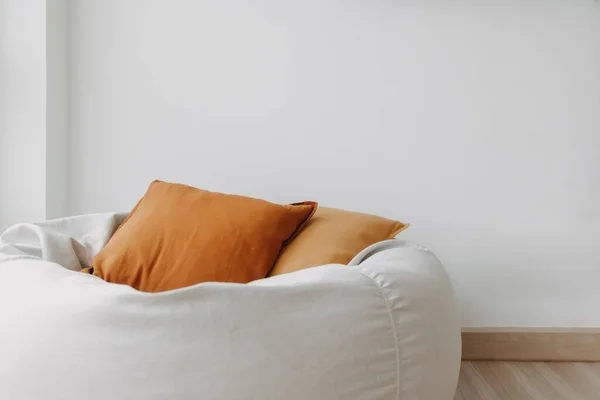 窗户旁边的白色房间里有棕色的枕头和豆袋沙发 — 图库照片