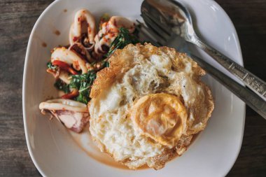 Tayland pilavı, kızarmış kalamar, fesleğen ve sahanda yumurta..