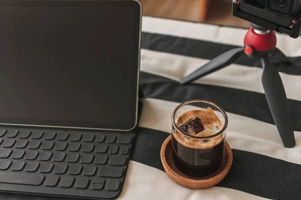 含有三脚架相机和笔记本电脑的内容创建者桌上的黑咖啡 — 图库照片