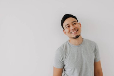 Çekiciliğiyle mutlu Asyalı bir adam ve rahat bir poz..