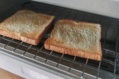 Automatic white breads toaster steamed oven with breads inside in the kitchen.