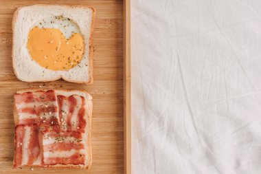 Easy and simple breakfast set of Bacon Sandwich served with black coffee on bed.