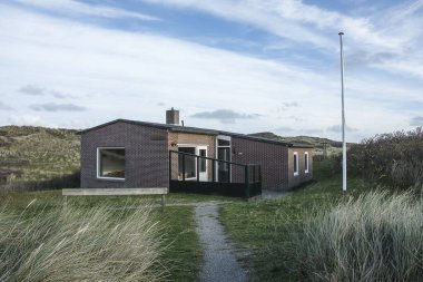 Wadden Adası 'nın kumullarında güneşli bir sonbahar gününde Vlieland' da bir tatil evi.