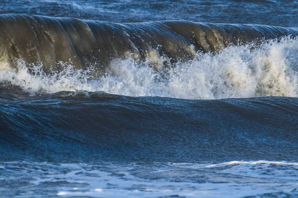 Fırtınalı bir sonbaharda, Ouddorp köyünün yakınındaki Hollanda sahillerine büyük dalgalar köpük saçar.