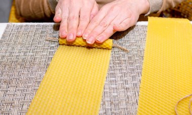 Balmumu yapma işlemi. Kadın dekoratif mum yapıyor. Adım adım talimat veriyorum. Üçüncü adım. Çarpıtma. Mum oluşumu