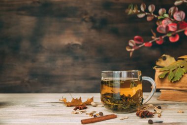 Koyu ahşap bir arka planda, ahşap bir masada çay fincanı..