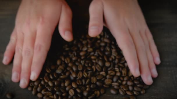 男性の手は一握りのコーヒー豆を取り 彼らの手の手のひらにそれらを保持します ローストアラビカコーヒー豆 — ストック動画